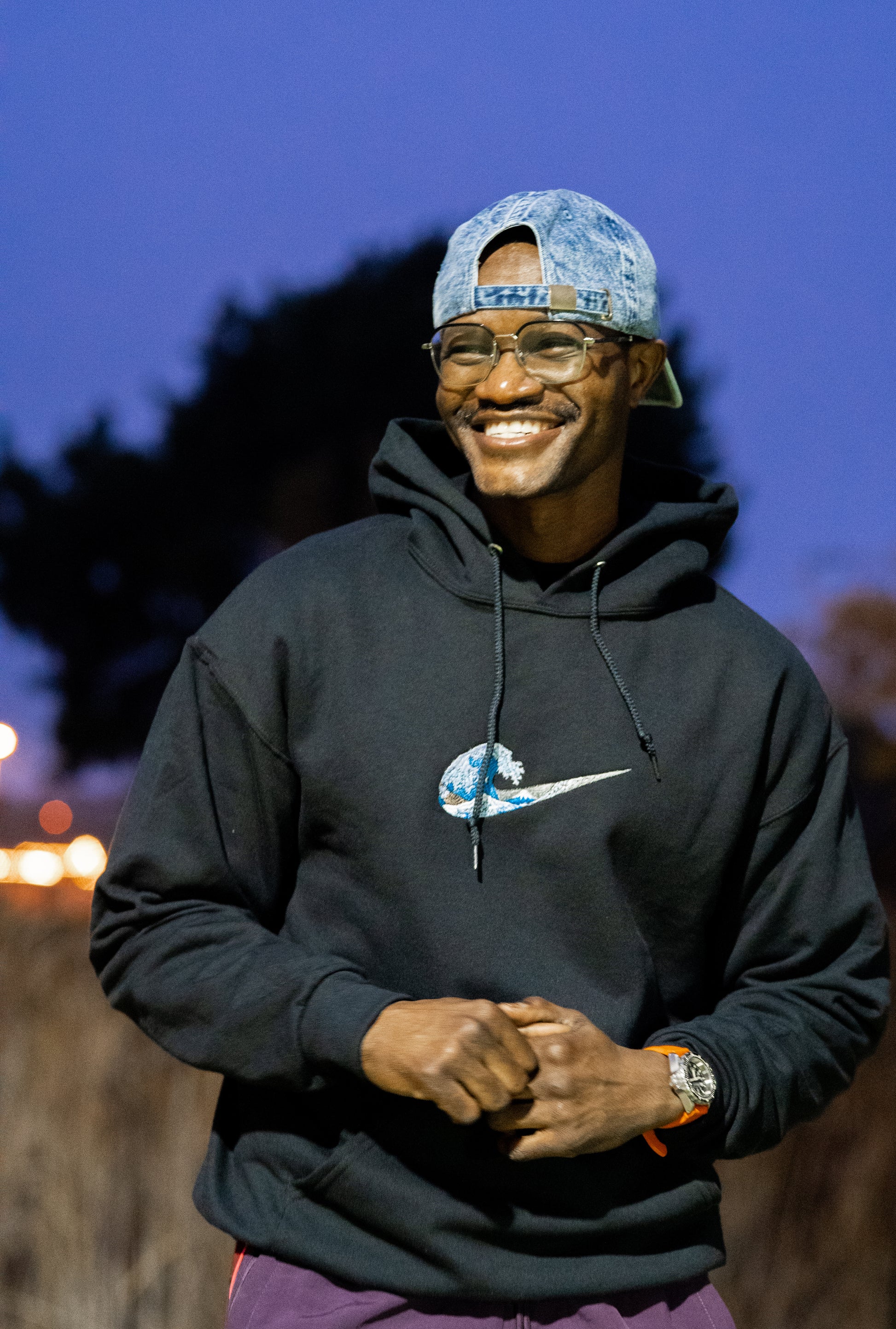 Custom wave embroidered black hoodie worn by man outdoors — Simply Love LLC
