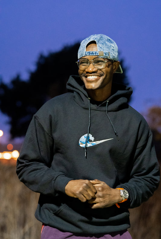 Custom wave embroidered black hoodie worn by man outdoors — Simply Love LLC